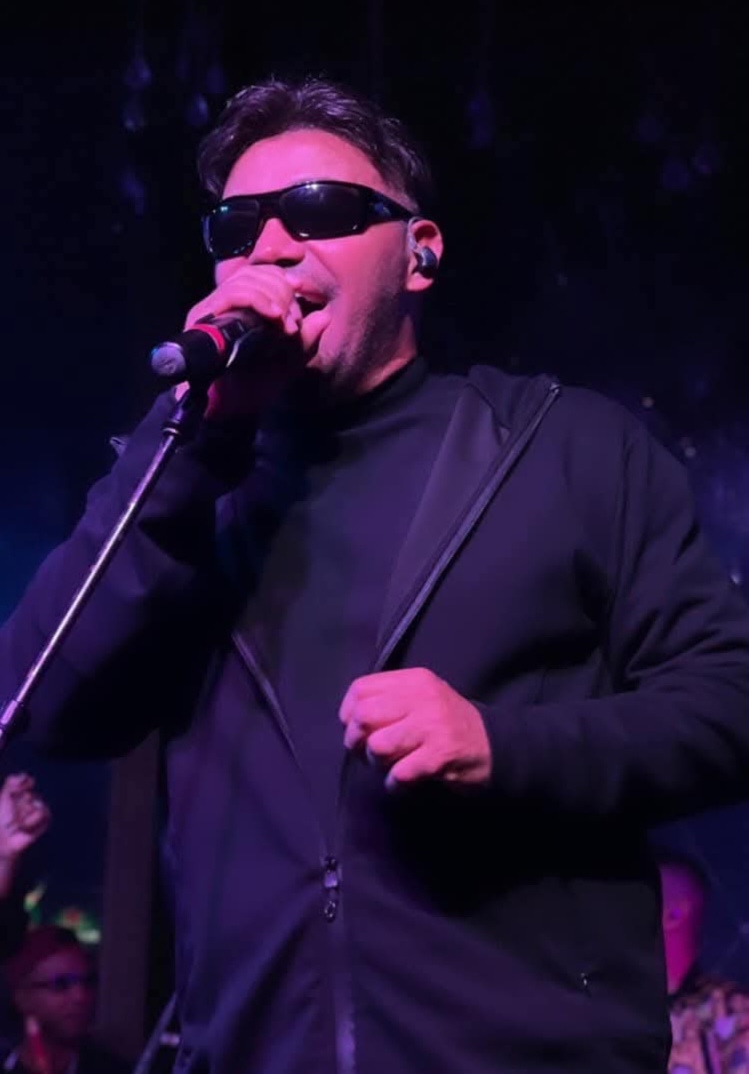 Manolín performing live with dark sunglasses